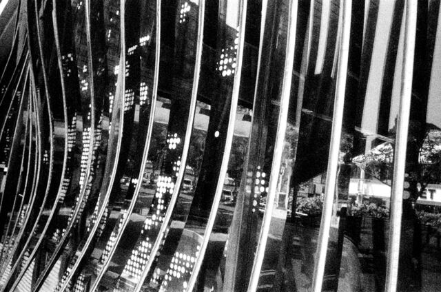 a rippled mirror facade weaving the street into bright strips